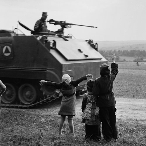 Foto Bill Perlmutter, Children Waving at U.S. Tanks, Germany, 1956