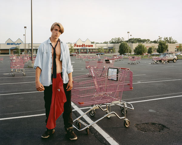 Foto Joel Sternfeld, Young Man Gathering Shopping Carts, Huntington, New York, July 1993